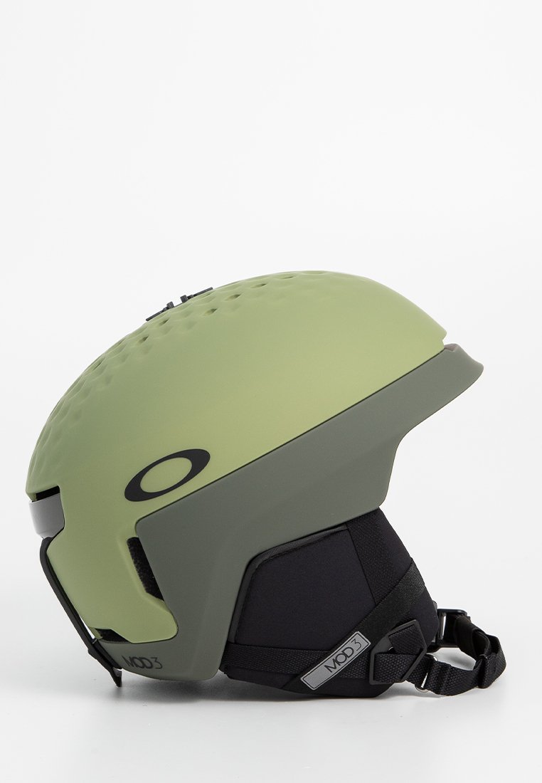 Zielony kask narciarski o aerodynamicznym kształcie, teksturowanej powierzchni, regulowanym pasku i otworach wentylacyjnych z boku. Posiada emblemat z przodu.