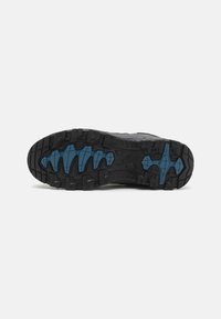 Schwarze Trailrunning-Schuhsohle mit einem robusten Muster, das auffällige Stollen und blaue Akzente für zusätzlichen Halt bietet. Hergestellt aus strapazierfähigem Gummi.