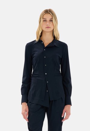 Camicia a maniche lunghe blu navy con chiusura a bottoni, vestibilità su misura, colletto a punta e texture morbida. Presenta arricciature laterali delicate.