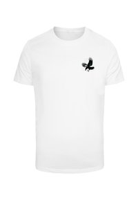 Hvid bomulds t-shirt med en sort grafik af en fugl med udfoldede vinger på venstre brystområde. Korte ærmer, rund hals.