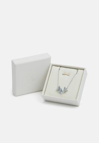 Srebrny naszyjnik z dwoma wisiorkami w kształcie żurawi z niebieskimi akcentami. Prezentowany w białym pudełku o teksturowanym wykończeniu i miękkim wyściółce wewnętrznej.