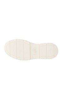 Witte rubberen schoenzool met textuur grooves, een ronde neus en een gladde middensectie met subtiel logo tussen de ribbels.