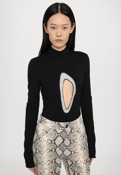 Black long-sleeve bodysuit featuring a large oval cutout edged in silver rhinestones, paired with beige and gray snake print pants.