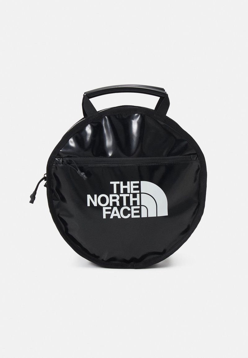 Okrągła czarna torba na zamek z górnym uchwytem i białym logo "THE NORTH FACE" na przedniej kieszeni.
