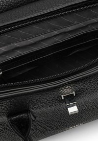 Schwarze Lederhandtasche mit strukturierter Oberfläche, ausgestattet mit Reißverschlusstaschen und einem metallischen Verschluss. Futter zeigt ein dezentes Muster.