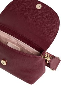 Bordowa skórzana torebka o fakturowanej powierzchni, złote okucia i zamek błyskawiczny. Wnętrze wyłożone jasną tkaniną.