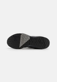 Sole di scarpa sportiva nera con un motivo testurizzato per una migliore aderenza, con un'accattivante accentuazione del logo Reebok grigio vicino al tallone. Realizzata in materiale gommoso.
