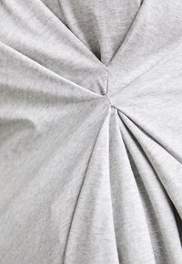 Šedá bavlněná látka s skládacím vzorem, obsahující shromážděné části sbíhající se do centrálního bodu. Hladká textura, měkká a elastická.