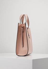 Růžová kožená kabelka ve strukturovaném tvaru s černými akcenty a dvěma horními uchy. Obsahuje dekorativní přední pásek a zlaté kování.