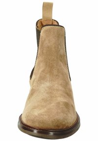 Beige Wildleder-Ankle-Boot mit elastischen Seitenpaneelen, einer Ziehschlaufe und einer abgerundeten Spitze. Verfügt über eine robuste braune Sohle und dezente Nähte.