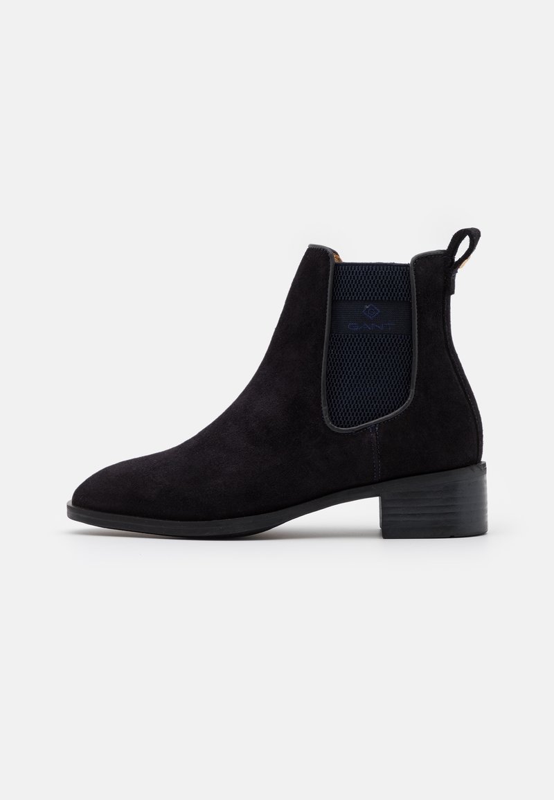 Botte Chelsea en daim noir avec panneau élastique sur le côté, languette de tirage, petit talon empilé et bout rond, présentée de profil sur fond blanc.