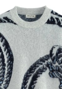 Pull en tricot gris clair avec un col rond ; présente des motifs abstraits bleu foncé et bleu clair sur toute la surface ; tissu doux et texturé.
