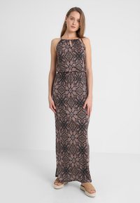 Vestido maxi de tela estampada con escote halter, cintura alta y diseño floral en tonos negro, rosa y crema.