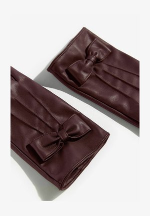 Bordeaux læderhandsker med sløjfe-accent, pleated design og glat tekstur, der fremhæver en tætsiddende og elegant silhuet.