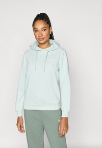 Φούτερ με κουκούλα σε ανοιχτό μέντα πράσινο χρώμα, με χαλαρή εφαρμογή, κορδόνι στην κουκούλα και ριμπ μανσέτες. Διαθέτει λευκή επιγραφή "LIMITLESS" στο στήθος.