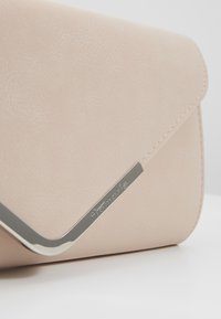 Clutch rosa cipria realizzato in pelle sintetica texturizzata, con un accento metallico argento sulla patta e un design elegante e strutturato.
