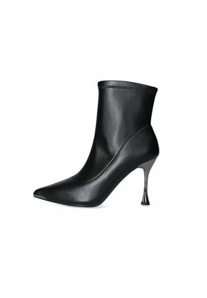 Stivale alla caviglia nero realizzato in pelle liscia, con punta affusolata e un tacco in metallo lucido e slanciato. Cuciture decorative alla caviglia.