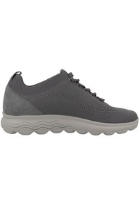 Scarpa sportiva grigia con tomaia in mesh traspirante, dettagli in suede, design texturizzato e suola in gomma con un motivo a onde, ammortizzata.