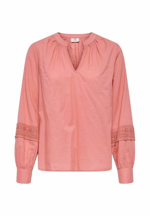 Blouse rose à manches longues avec col en V, encolure froncée et détails en dentelle sur les manches au-dessus des poignets.
