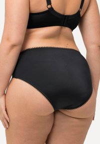 Zwarte high-waisted onderbroek met decoratieve picotrand langs de tailleband. Glad materiaal met een matte afwerking, biedt volledige bedekking.