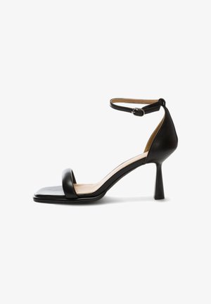 Sandale noire en cuir à talon haut avec bride de cheville et boucle, bout ouvert et semelle avant carrée.
