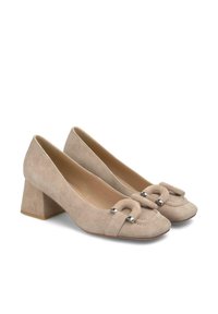 Chaussures à talons carrés en daim beige avec un bout arrondi, ornées d'un nœud décoratif et d'accents argentés à l'avant.
