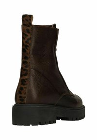 Brown leather ankle boot featuring a leopard print back panel, textured finish, curved design, and a chunky black rubber sole.