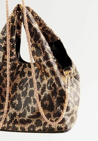Črna in zlata torbica s sijočimi bleščicami in leopardjim vzorcem, ki ima pleteno zlato verižico in gladko črno usnjen osnovo.