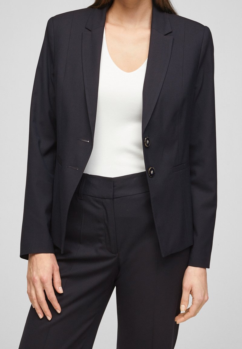 Dark navy blazer made of smooth fabric, featuring a notched lapel, two buttons, and a tailored fit with subtle pinstripes.