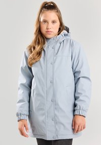 Vaaleansininen vedenpitävä takki, jossa on kiristettävä huppu, nepparilla suljettava etuosa, joustavat hihansuut ja kaksi sivutaskua. Silkkinen pinta.