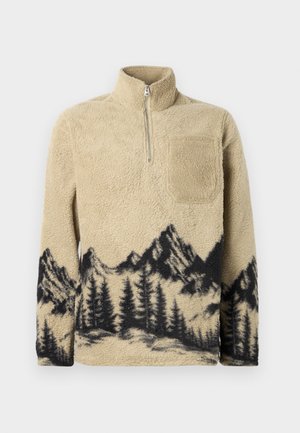 Beige fliisist soe särk poolsuudmega. Omab tekstuurset pinda ning musta värvi mäe ja puu siluetti, mis on trükitud hemmi ääres.