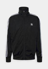 Svart Adidas zip-up träningsjacka med vit tre-stripesdetaljering på ärmarna och logotyp på vänster bröst, hög krage och ribbad mudd.