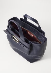 N�ámořnická kožená taška přes rameno s texturovaným povrchem, zlatými kovovými doplňky, dvojitými uchy a zipovou kapsou, která odhaluje červený interiér.