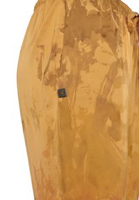 Pantaloni jogger giallo-marroni con vita regolabile, caratterizzati da motivi astratti di spruzzi e un piccolo tag metallico sul lato.