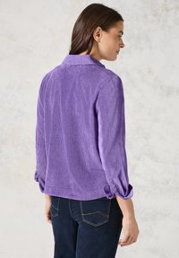 Camicia button-up in corduroy viola con maniche arrotolate e colletto, caratterizzata da una finitura tessurizzata e una vestibilità rilassata.