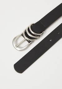 Black leather belt with a silver buckle featuring three circular accents. Textured finish, with holes for adjustment and a tapered end.