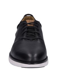 Černá kožená bota s texturovaným povrchem, kulatou špičkou a černými tkaničkami, s bílou gumovou podrážkou pro kontrast.