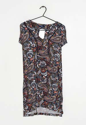 Robe à manches courtes avec des motifs colorés paisley et floraux, accrochée à un cintre noir sur fond blanc.