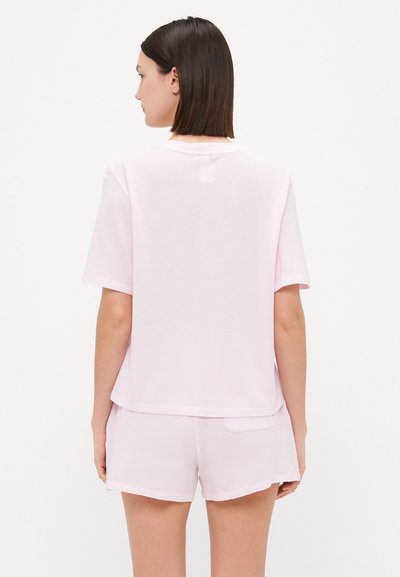 Pink short-sleeve t-shirt with a relaxed fit, made from soft fabric, paired with matching shorts featuring a subtle pocket detail.