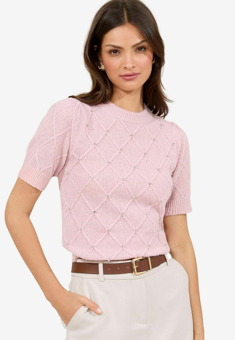 Maglione corto a maniche corte di colore rosa chiaro, con un motivo a diamante e decorazioni. Presenta un collo rotondo e polsini a costine.