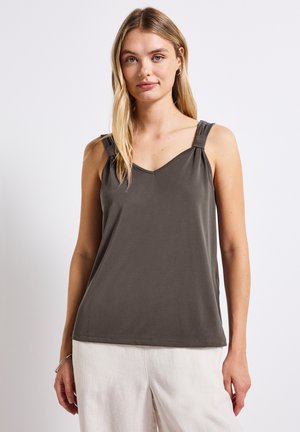 Top senza maniche grigio scuro con scollatura a V. Presenta spalline annodate e tessuto morbido e liscio, abbinato a pantaloni chiari e larghi.