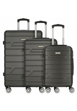 Set di valigie a tre pezzi in grigio scuro. Guscio rigido testurizzato con linee geometriche, manici telescopici e otto ruote per stabilità.