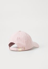 Adjustable pink cotton cap with a curved brim, gold-tone buckle at the back, and a patterned interior lining.