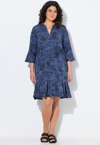 Abito blu navy con fondo svasato e maniche a tre quarti, caratterizzato da un motivo nero giocoso. Realizzato in tessuto leggero.