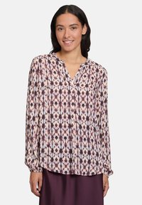 Blusa a maniche lunghe in tessuto leggero con un motivo geometrico viola e crema, dotata di scollatura a V e dettaglio con bottoni al colletto.