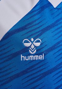 Maillot de sport bleu avec des rayures texturées en diagonale, col blanc et logo "hummel" brodé avec un design d'abeille en blanc.