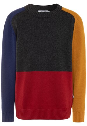 Sweter z dzianiny w blokach kolorów: ciemnoszary na górze, czerwony z przodu, granatowy na lewym rękawie i musztardowy na prawym rękawie. Sweter ma prążkowane mankiety i kołnierz.