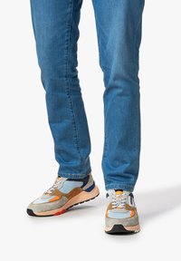 Bunt gemusterte Sportschuhe aus einer Mischung aus Wildleder und Mesh-Materialien, mit einem Design in Grau, Orange und Blau. Profilierte Gummisohle, Schnürschuh-Stil.
