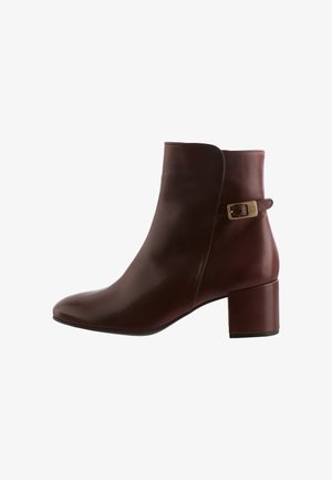Brown leather ankle boot with a sleek design, rounded toe, and a medium block heel. Features a small buckle accent on the side.