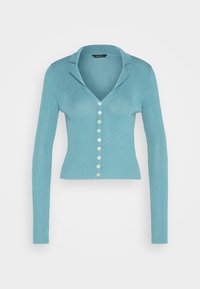 Un cardigan a maniche lunghe, a costine, di colore azzurro chiaro, con un collo a bavero e una fila di sette bottoni di colori vari. 